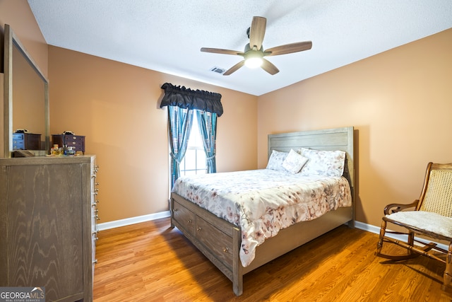 bedroom featuring visible vents, ceiling fan, baseboards, and light wood-style floors