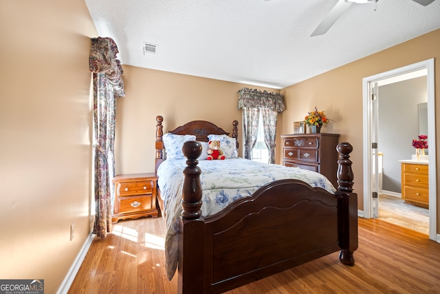 bedroom with visible vents, ceiling fan, baseboards, and wood finished floors