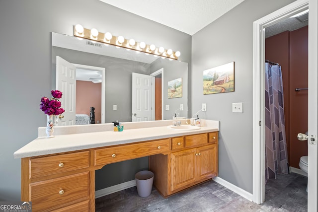 bathroom with visible vents, toilet, a shower with shower curtain, baseboards, and vanity