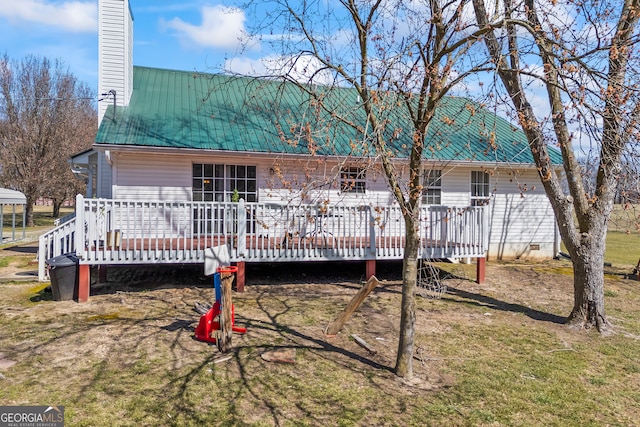 back of house with a deck, metal roof, a chimney, and crawl space