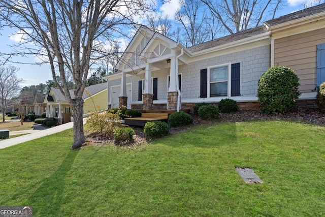 craftsman inspired home featuring driveway, an attached garage, covered porch, and a front yard