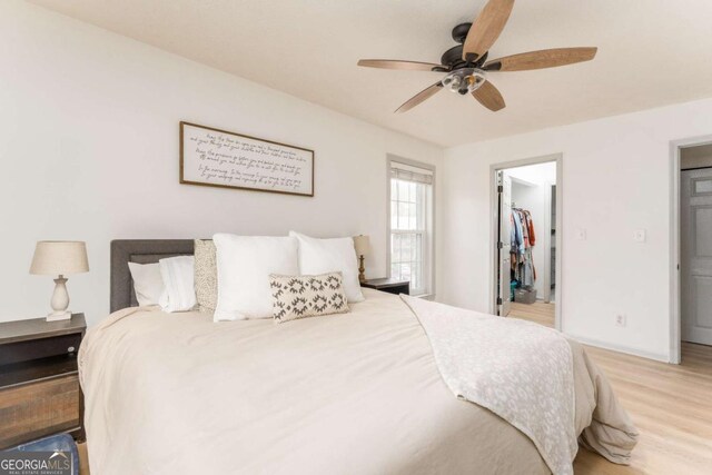 3529 Essex Ave Unit 75, Atlanta, GA 30339 - bedroom with a walk in closet, a ceiling fan, wood finished floors, a closet, and baseboards