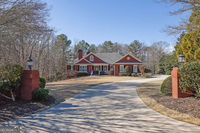 view of front of property with a chimney and driveway