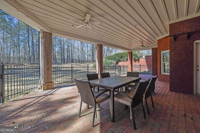 view of patio with outdoor dining space, a ceiling fan, and fence