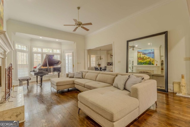 living room with ceiling fan, dark wood-style flooring, a fireplace, and ornamental molding