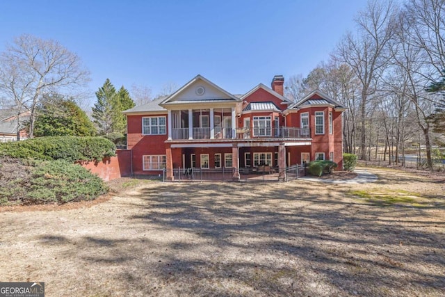 view of front of house featuring a wooden deck, a chimney, and a patio