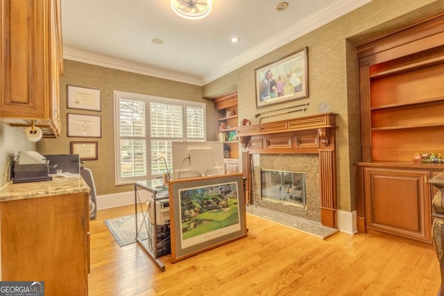 sitting room featuring a high end fireplace, baseboards, built in features, ornamental molding, and light wood-style flooring