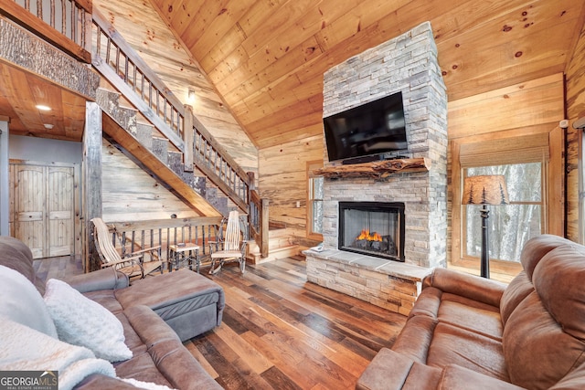 living area with high vaulted ceiling, wood-type flooring, wood walls, a fireplace, and wood ceiling