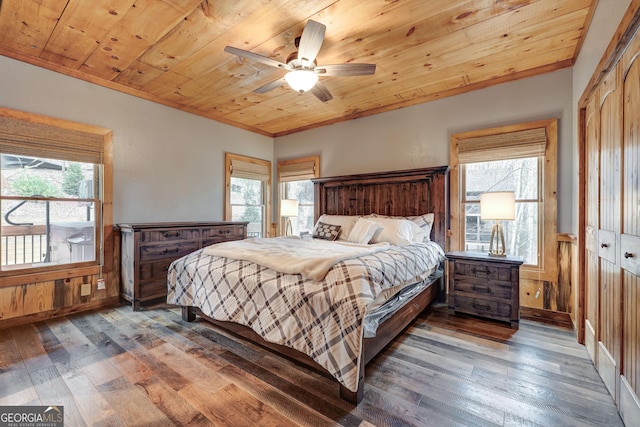 bedroom featuring hardwood / wood-style floors, wooden ceiling, crown molding, and a ceiling fan