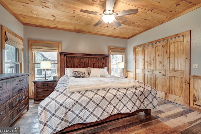bedroom with a closet, multiple windows, wood ceiling, and wood finished floors