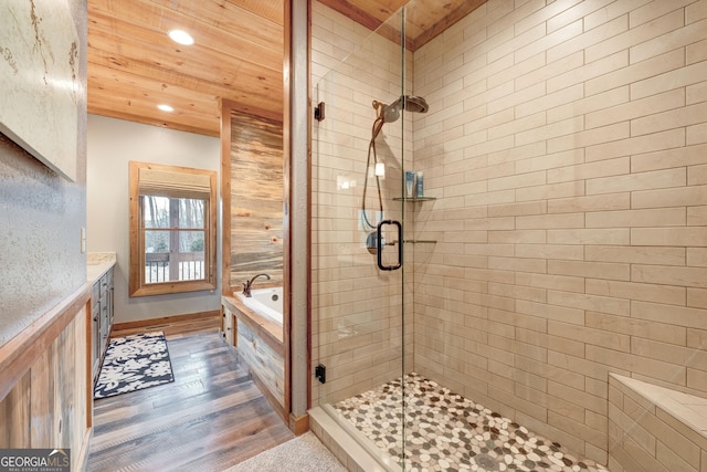 bathroom featuring wood finished floors, a garden tub, a stall shower, and wooden ceiling