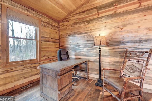 office featuring wooden walls, wood finished floors, visible vents, vaulted ceiling, and wooden ceiling