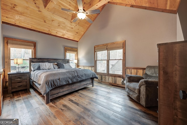 bedroom with wooden ceiling, hardwood / wood-style flooring, multiple windows, and a wainscoted wall