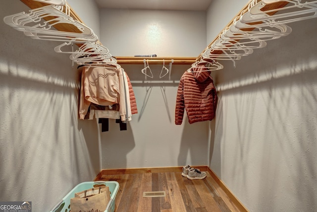 spacious closet featuring wood finished floors and visible vents