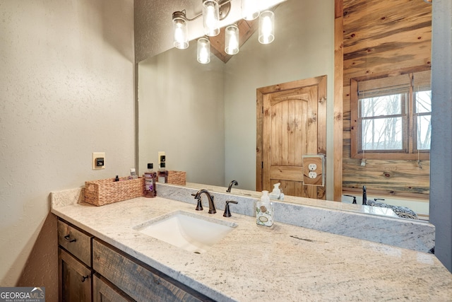 bathroom with vanity and a textured wall