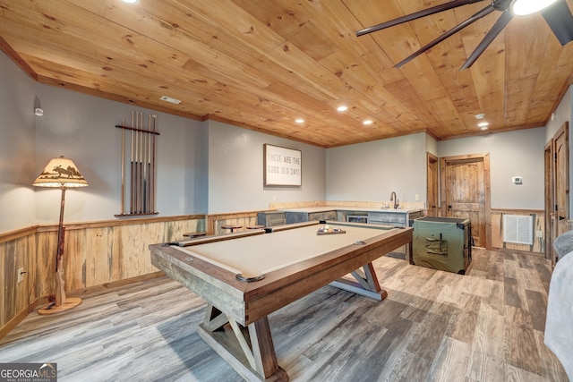 rec room with a wainscoted wall, ornamental molding, recessed lighting, wooden ceiling, and light wood finished floors