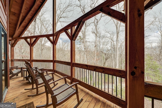 sunroom featuring lofted ceiling, wood ceiling, and a wealth of natural light