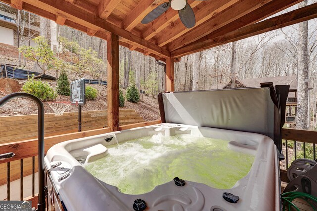 wooden deck with ceiling fan and a hot tub