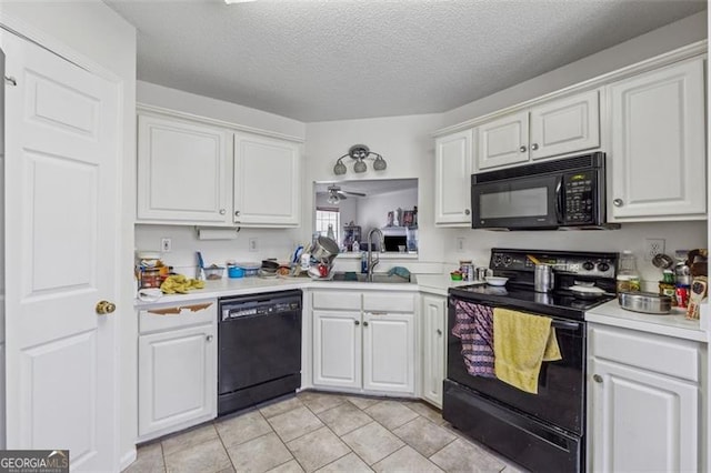 kitchen featuring white cabinets, black appliances, light countertops, and a sink