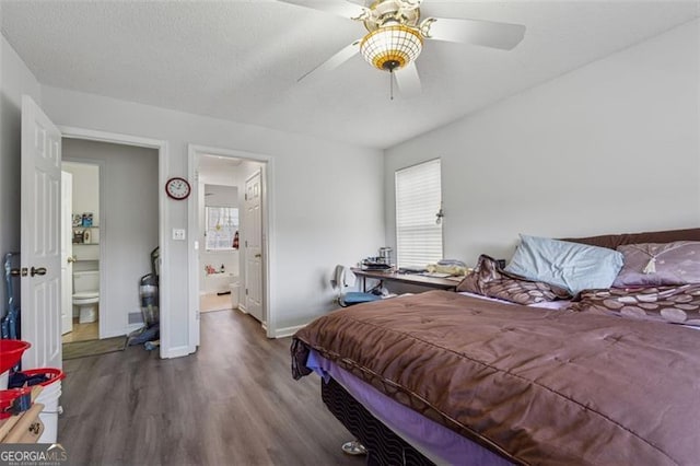 bedroom featuring multiple windows, a textured ceiling, baseboards, and wood finished floors