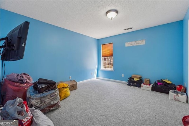 playroom with visible vents, carpet floors, a textured ceiling, and baseboards