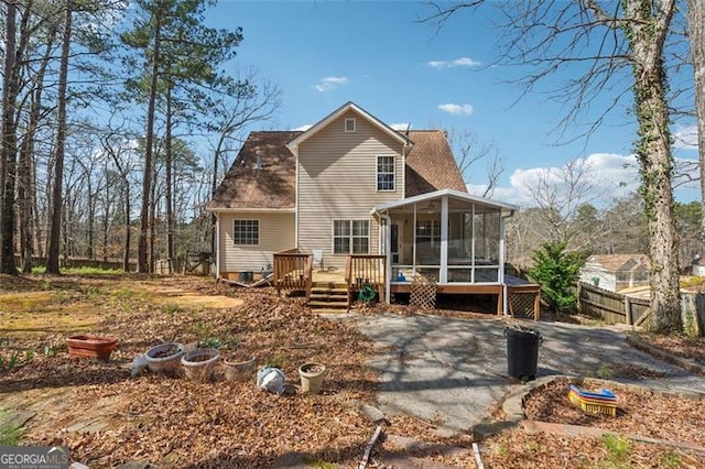 back of house with fence, a deck, and a sunroom