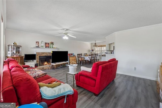 living room with a stone fireplace, a textured ceiling, ceiling fan, and wood finished floors