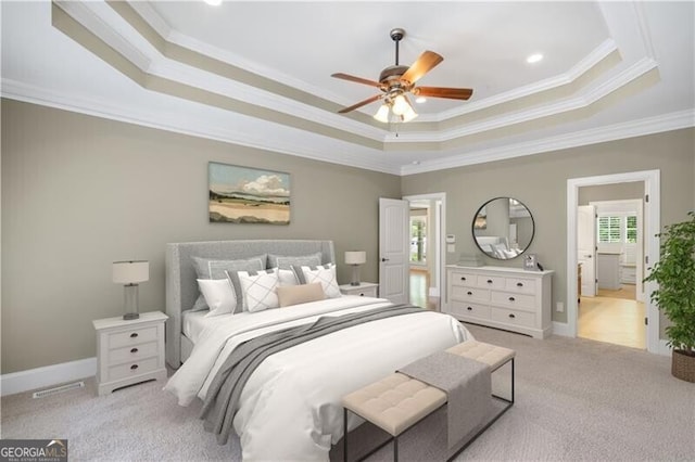 carpeted bedroom featuring visible vents, ornamental molding, a tray ceiling, baseboards, and ceiling fan