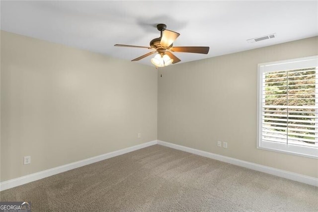 spare room with visible vents, baseboards, light carpet, and a ceiling fan