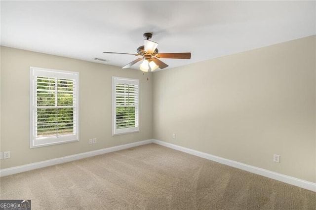 spare room with visible vents, baseboards, ceiling fan, and carpet flooring