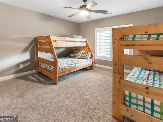 carpeted bedroom with visible vents, baseboards, and a ceiling fan