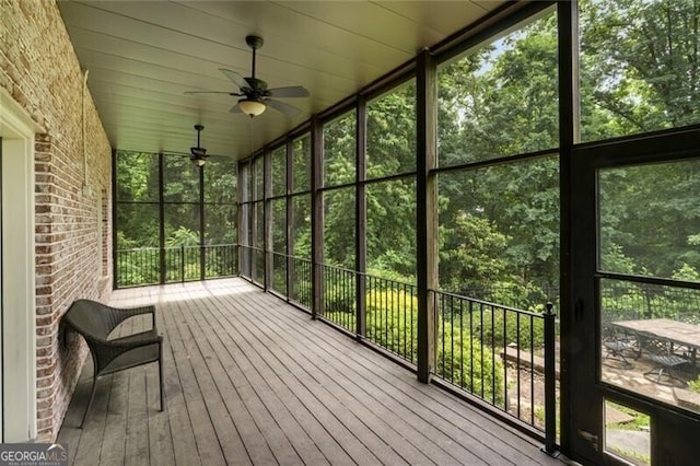 unfurnished sunroom featuring ceiling fan