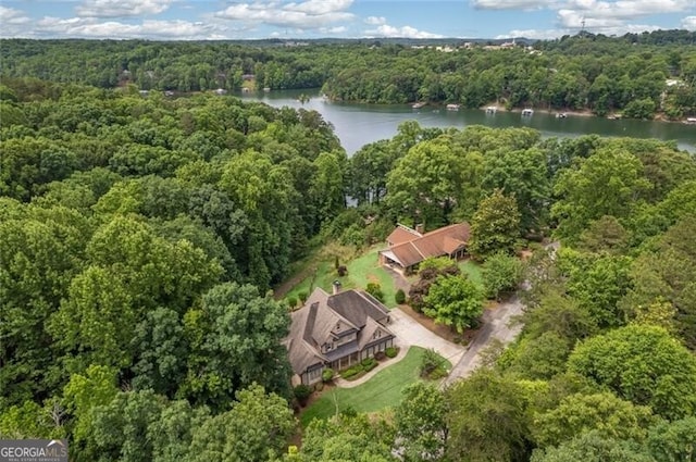 bird's eye view featuring a wooded view and a water view