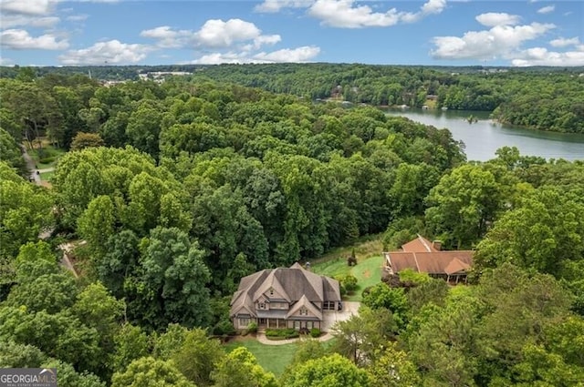 birds eye view of property featuring a forest view and a water view