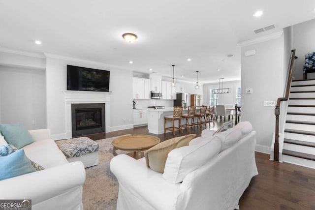 living room featuring visible vents, recessed lighting, dark wood-style flooring, stairs, and crown molding