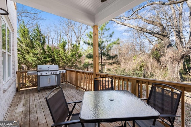 deck featuring outdoor dining area and a grill