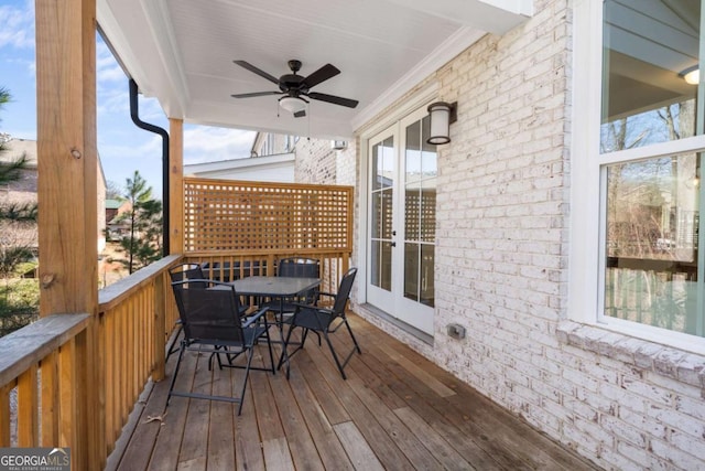 deck with outdoor dining space, french doors, and a ceiling fan