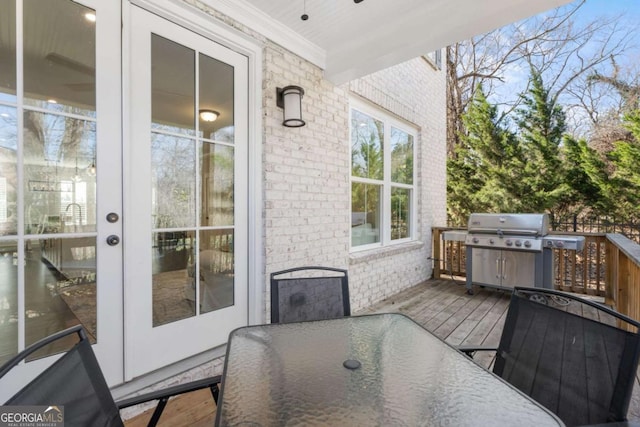 wooden terrace featuring area for grilling, outdoor dining area, and french doors