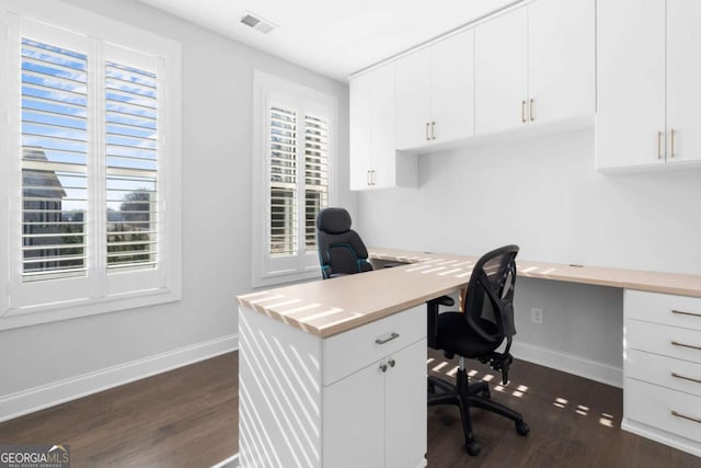 office with built in desk, plenty of natural light, and baseboards