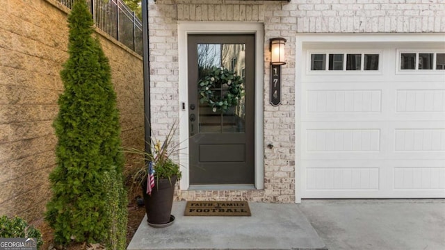 view of exterior entry featuring fence and a garage