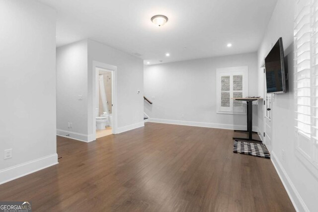 unfurnished living room with recessed lighting, baseboards, and wood finished floors