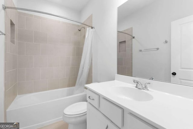 bathroom featuring vanity, shower / tub combo, and toilet