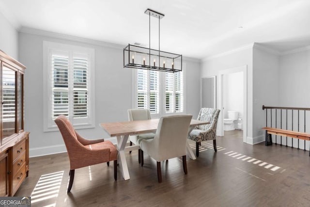 dining room featuring crown molding, a notable chandelier, dark wood-style floors, and baseboards