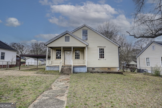 bungalow-style house with a front yard, fence, driveway, a porch, and crawl space