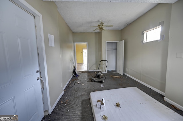 workout room featuring a ceiling fan and baseboards