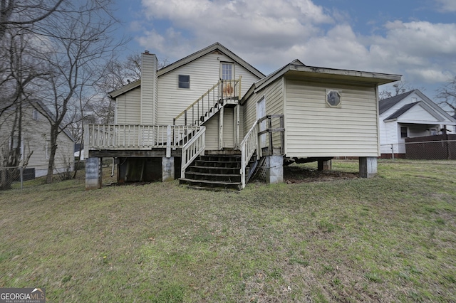 rear view of property with stairs, a deck, a lawn, and fence