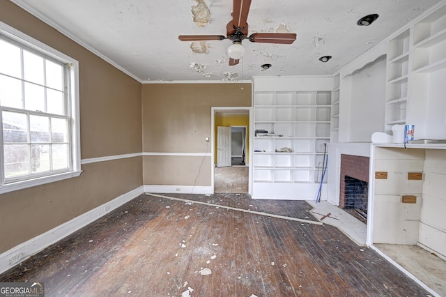 unfurnished living room with baseboards, built in shelves, hardwood / wood-style floors, and a fireplace