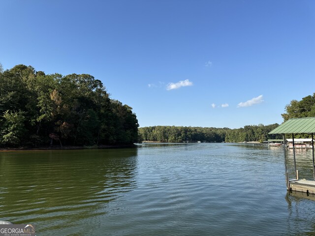 view of dock with a forest view and a water view