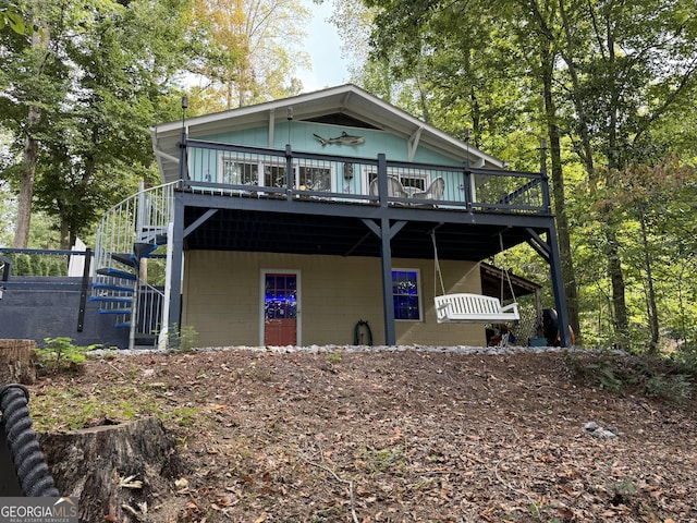view of front facade with stairs, a wooden deck, and concrete block siding