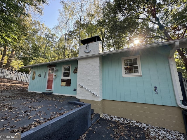 view of front of property featuring a chimney and fence